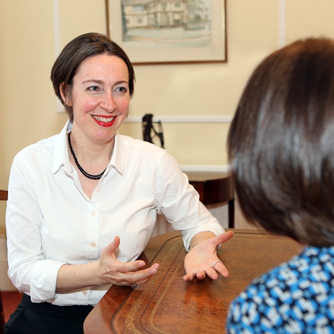 Ingrid Pope sitting at a desk coaching a female client