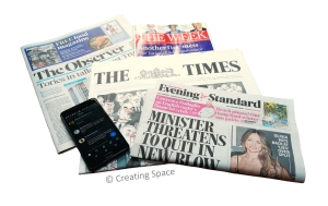 Photograph of several newspapers and a mobile phone