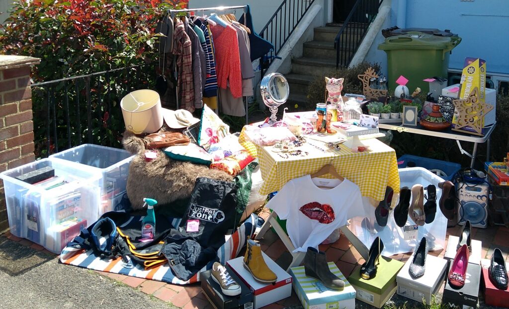 Photo of a stall holder selling a variety of items including clothing, accessories and household items